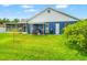 The blue home has a lush lawn and patio with a grill at 28390 Openfield Loop, Wesley Chapel, FL 33543