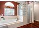 This bathroom features a soaking tub, a glass block window, and a separate shower at 28390 Openfield Loop, Wesley Chapel, FL 33543