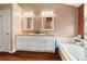 Bright bathroom features a double vanity with granite countertops and a soaking tub at 28390 Openfield Loop, Wesley Chapel, FL 33543