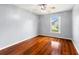 This bedroom features gleaming hardwood floors, a ceiling fan, and a sun-filled window at 28390 Openfield Loop, Wesley Chapel, FL 33543