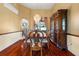 Elegant dining room with hardwood floors, a decorative chandelier, and a large china cabinet, perfect for entertaining at 28390 Openfield Loop, Wesley Chapel, FL 33543