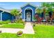 Close-up of home's front entrance featuring lush landscaping, a paver walkway, and an arched entryway at 28390 Openfield Loop, Wesley Chapel, FL 33543