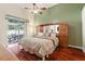 Spacious main bedroom with hardwood floors, a ceiling fan, and a sliding glass door leading to an outdoor patio at 28390 Openfield Loop, Wesley Chapel, FL 33543