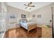 Charming bedroom features a wood-frame bed, ceiling fan, and a large window at 2847 Mossy Timber Trl, Valrico, FL 33596