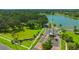 Scenic view of community entrance with lush landscaping, palm trees, and a glimpse of the lake at 2847 Mossy Timber Trl, Valrico, FL 33596