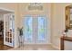 Elegant foyer with decorative glass doors, arched transom window, and neutral tile flooring at 2847 Mossy Timber Trl, Valrico, FL 33596