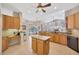 Well-lit kitchen featuring an island, wood cabinetry, and modern appliances in an open layout at 2847 Mossy Timber Trl, Valrico, FL 33596