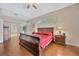 Spacious main bedroom with wood floors, tray ceiling, and ensuite bathroom at 2847 Mossy Timber Trl, Valrico, FL 33596