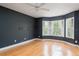 Bedroom with hardwood floors, bay windows dressed with shutters, and textured dark gray walls at 2876 Bayshore Trails Dr, Tampa, FL 33611