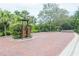 Community entrance gate featuring brickwork, mature trees, and secure access for residents at 2876 Bayshore Trails Dr, Tampa, FL 33611