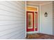 A bright red front door with white trim and shuttered windows, offering a welcoming entrance at 2876 Bayshore Trails Dr, Tampa, FL 33611