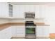 Gas range and stainless microwave featured in this bright kitchen with white cabinets and light countertops at 2876 Bayshore Trails Dr, Tampa, FL 33611