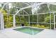 A backyard pool enclosed with a screen, along with lush, mature landscaping offering privacy and beauty at 2876 Bayshore Trails Dr, Tampa, FL 33611