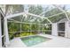 Screened in pool that is surrounded by lush tropical landscaping, offering a private and serene oasis at 2876 Bayshore Trails Dr, Tampa, FL 33611