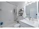 Well-lit bathroom featuring a white tub, toilet, vanity, and decorative wall shelving for storage at 3053 Pointeview Dr, Tampa, FL 33611