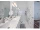 Bright bathroom featuring a double sink vanity, large mirrors, and a glass enclosed shower at 3053 Pointeview Dr, Tampa, FL 33611