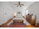 Bright bedroom featuring a ceiling fan, wood floors, closet, and a queen-size bed with bench at 3053 Pointeview Dr, Tampa, FL 33611