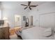 A bedroom with a ceiling fan, wood floor, double closets, and bathroom access with queen bed at 3053 Pointeview Dr, Tampa, FL 33611