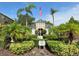 Community clubhouse featuring lush landscaping, mature palms, and an American flag at 3053 Pointeview Dr, Tampa, FL 33611