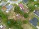 Aerial view showing multiple homes, green lawns, mature trees, and a swimming pool, in a residential neighborhood at 3509 King George Ln, Seffner, FL 33584