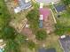 An aerial view reveals a home with a red roof, set among trees and adjacent to other homes in a residential area at 3509 King George Ln, Seffner, FL 33584
