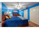 Bright bedroom with blue walls featuring a ceiling fan, a TV and lots of closet space at 3509 King George Ln, Seffner, FL 33584