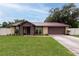 Charming single-story home featuring a well-manicured lawn and a lovely brown metal roof at 3509 King George Ln, Seffner, FL 33584