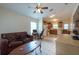 Cozy living room with tile flooring and a ceiling fan, open to the kitchen area at 3509 King George Ln, Seffner, FL 33584