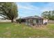 Backyard featuring a screened-in pool, manicured lawn, and mature trees offering shade and privacy at 3509 King George Ln, Seffner, FL 33584