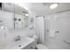 Bright bathroom featuring a shower with a curtain and a well-lit vanity with decorative accents at 4154 56Th N St # 720, Kenneth City, FL 33709
