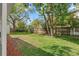 Spacious backyard with lush green grass, mature trees, and a wooden fence at 4309 W Empedrado St, Tampa, FL 33629