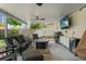 Comfortable covered patio area with cozy seating, a ceiling fan, grill, and TV at 4309 W Empedrado St, Tampa, FL 33629