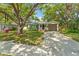 Charming single-story home featuring a well-manicured lawn, mature trees, and a convenient carport at 4309 W Empedrado St, Tampa, FL 33629