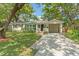 Charming single story home featuring a well maintained lawn, lush trees, and a private carport at 4309 W Empedrado St, Tampa, FL 33629