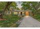 Charming single story home featuring a well maintained lawn, lush trees, and a private carport at dusk at 4309 W Empedrado St, Tampa, FL 33629