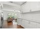 Open concept kitchen with white cabinetry, stainless appliances, and marble counters flowing into living area at 4309 W Empedrado St, Tampa, FL 33629