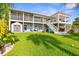 Beautiful two-story home with a spacious backyard, featuring a patio, pergola, and lush green lawn at 4523 Gulfstream Dr, Hernando Beach, FL 34607