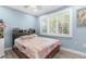 Light-filled bedroom with light blue walls, plantation shutters, and wood-look laminate flooring at 4523 Gulfstream Dr, Hernando Beach, FL 34607