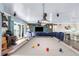 Open-concept living room featuring a pool table, modern entertainment center, and comfortable seating at 4523 Gulfstream Dr, Hernando Beach, FL 34607
