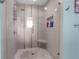 Modern shower featuring a pebble floor, built-in bench, and tiled walls with decorative accent strips at 4523 Gulfstream Dr, Hernando Beach, FL 34607