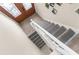 Interior staircase featuring gray carpeted treads, wood laminate flooring, and a decorative wood door at 4523 Gulfstream Dr, Hernando Beach, FL 34607