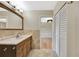 Bathroom boasts a wood vanity, ceramic tile, and direct access to a bedroom with hardwood floors at 4619 W Bay Villa Ave, Tampa, FL 33611