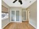 Bright bedroom with hardwood floors, a ceiling fan, access to an adjoined room, and patterned glass doors at 4619 W Bay Villa Ave, Tampa, FL 33611