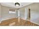 Bright bedroom featuring hardwood floors, a stylish light fixture, and a window with a woven shade at 4619 W Bay Villa Ave, Tampa, FL 33611