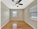 This bedroom boasts hardwood floors, a ceiling fan, and natural light from two windows at 4619 W Bay Villa Ave, Tampa, FL 33611