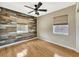 Bedroom with wood accent wall, ceiling fan, hardwood floors and two bright windows at 4619 W Bay Villa Ave, Tampa, FL 33611