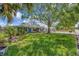 Charming single-story home with a lush green lawn and mature trees creating a welcoming curb appeal at 4619 W Bay Villa Ave, Tampa, FL 33611