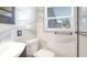 Modern bathroom featuring marble-like tiles, sleek fixtures, and a window for natural light at 5048 5Th S Ave, St Petersburg, FL 33707