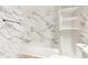 Bathroom view of bathtub and commode, features marbled walls and a built-in shelf at 5048 5Th S Ave, St Petersburg, FL 33707