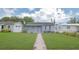 Inviting single-story home features a lush lawn and pathway to the entrance at 5048 5Th S Ave, St Petersburg, FL 33707